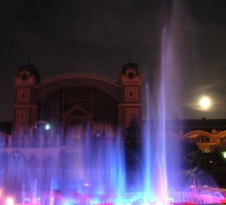 Singing fountain shown at night with lights sparkling through the water