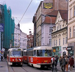 View of two streetcars passing on busy city street