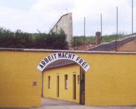 Notice the writing above the walkway. Prisoners walked under this sign after being cleansed and relieved of possessions for 'safe keeping.' ARBEIT MACHT FREI -- reads in English: Work Will Set You Free.